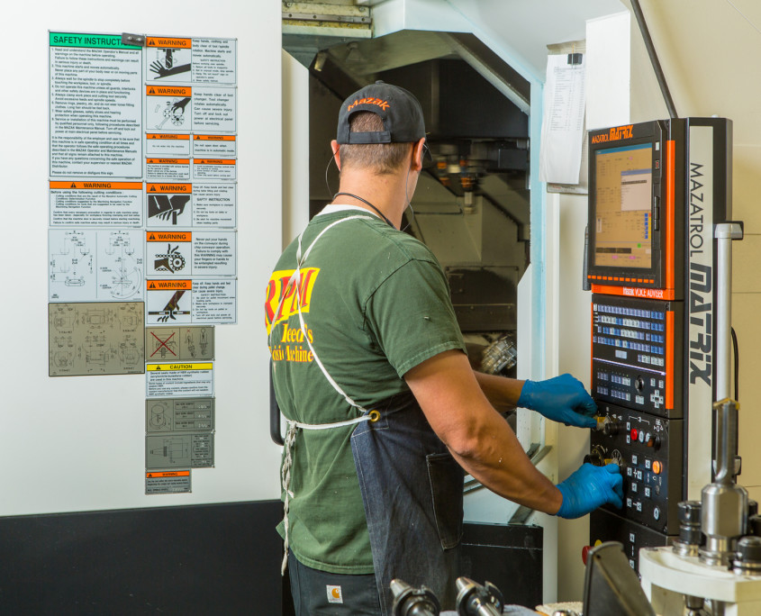image of worker working at a CNC machine